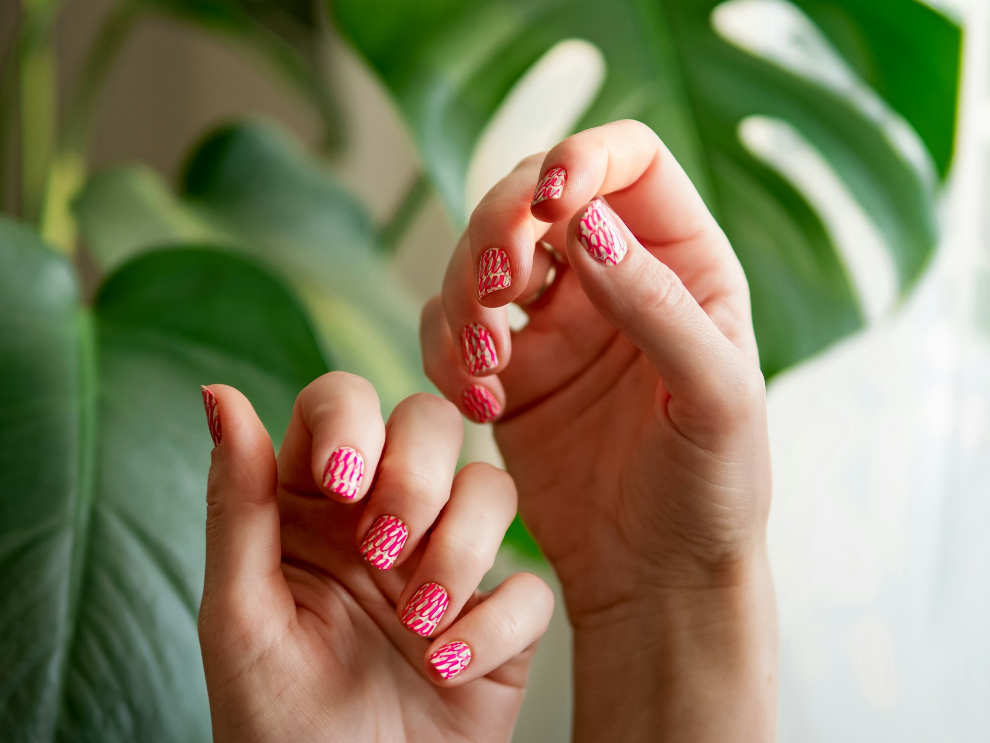 Hands with pink neon stamping nails manicure